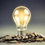 Light bulb and pile of coins